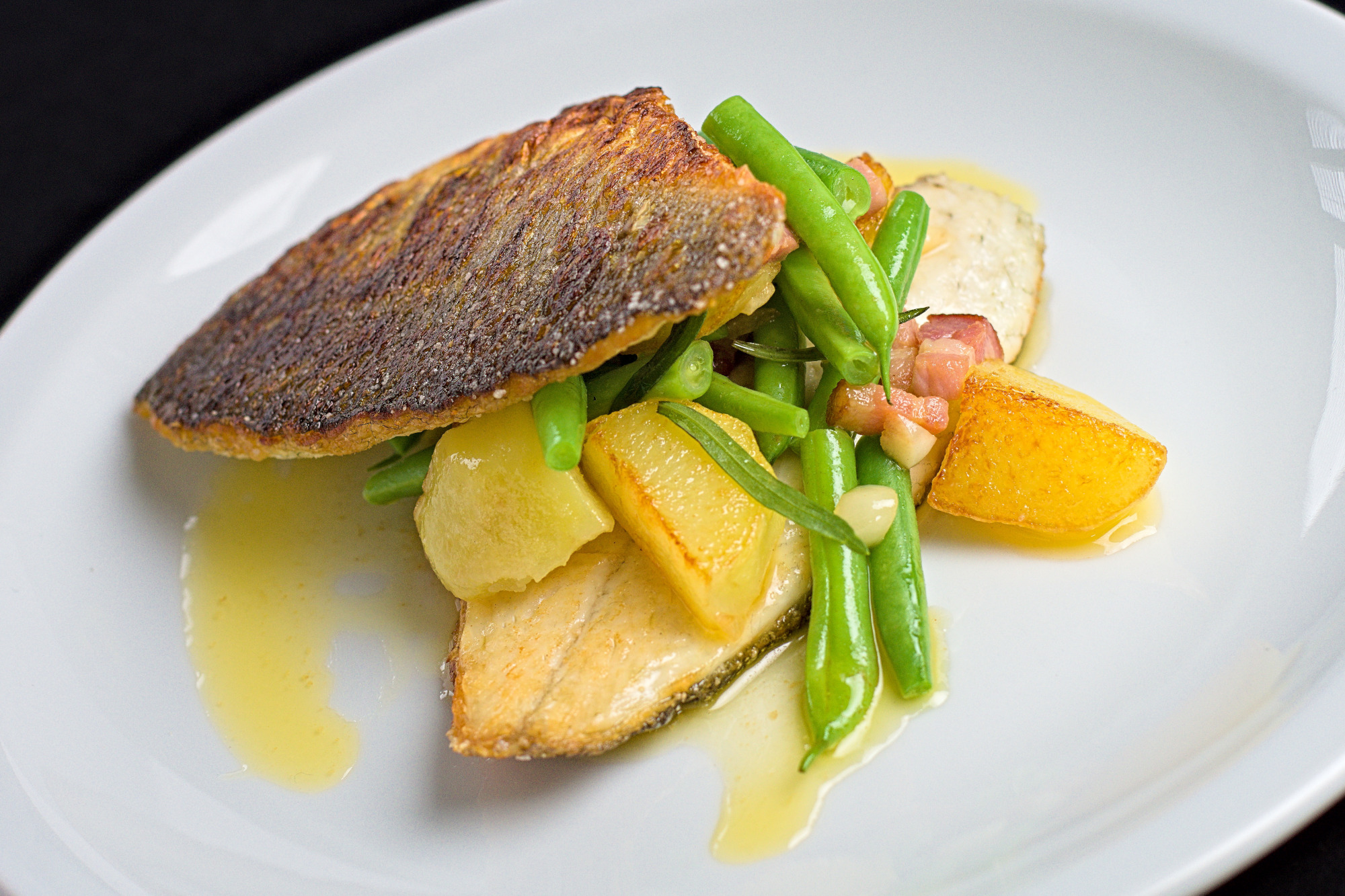 You are currently viewing Skindstegt filet af havbars med bønner, bacon og kartofler